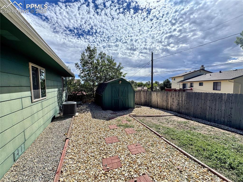 Image 7 of 8: Fenced backyard featuring a storage shed