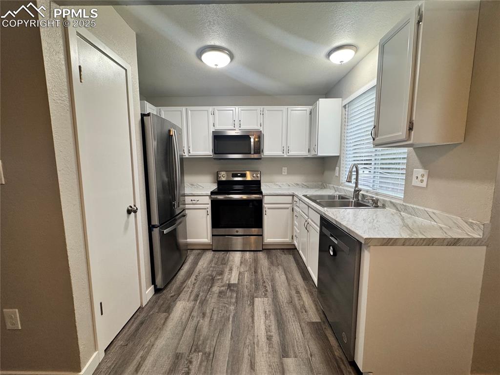 Image 11 of 24: Kitchen with light countertops, appliances with stainless steel finishe