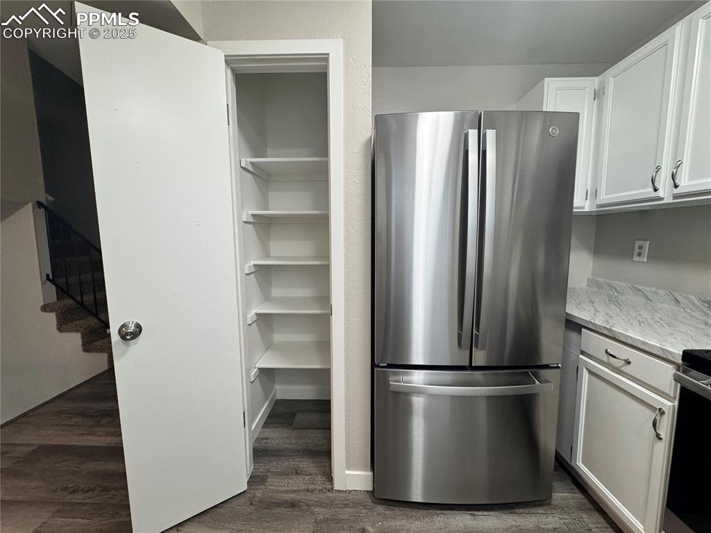 Image 12 of 24: Kitchen with freestanding refrigerator, white cabinets