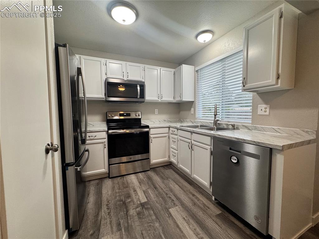 Image 13 of 24: Kitchen featuring light white cabinets, lvp flooring