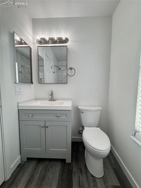 Image 18 of 24: Full bathroom featuring a textured wall, lvp floors, vanity, and tiled show