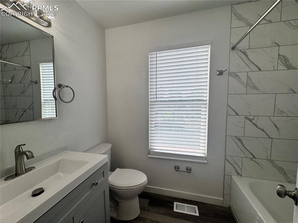 Image 20 of 24: Full bath with vanity, bathing tub / shower combination, lvp flooring