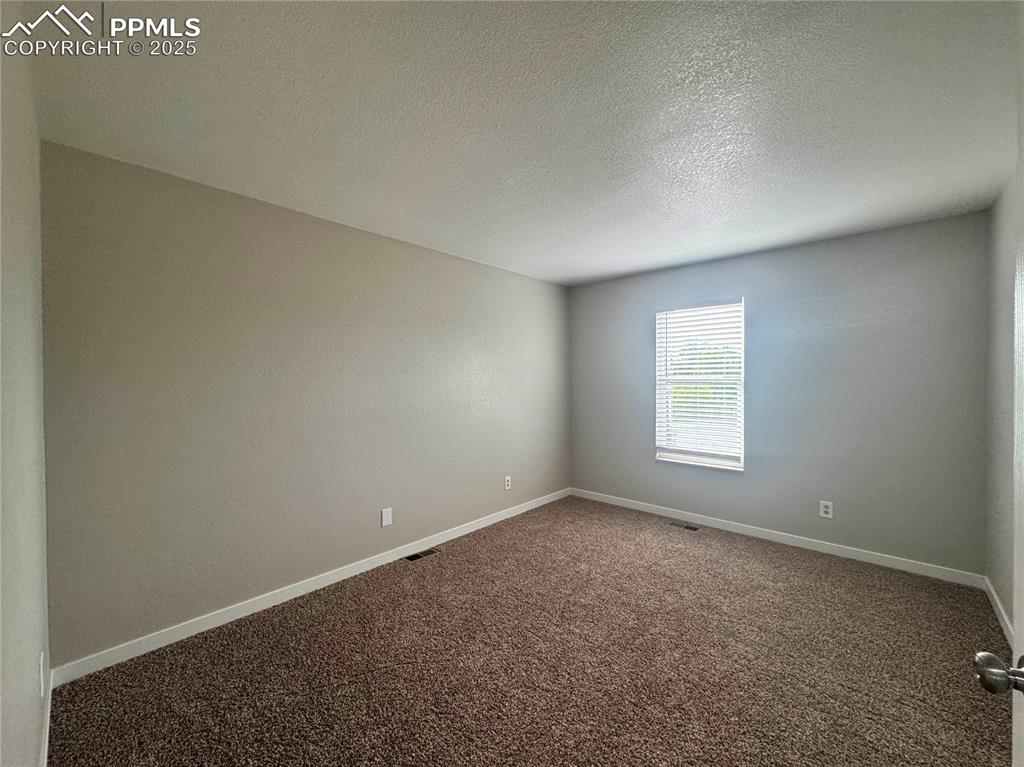 Image 21 of 24: Carpeted spare room featuring a textured ceiling and baseboards