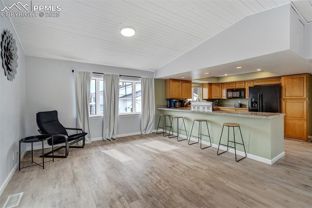 Image 10 of 31: Kitchen with oak cabinets, custom ceiling, a kitchen breakfast bar that sea