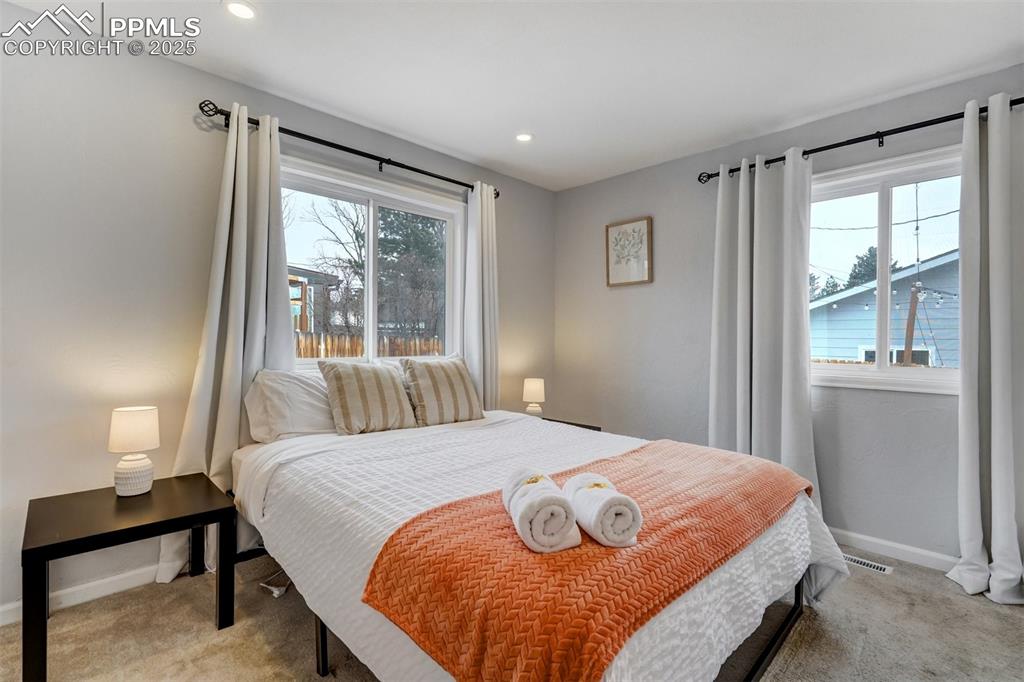 Image 14 of 31: 2nd  main level bedroom with light colored carpet and recessed lighting
