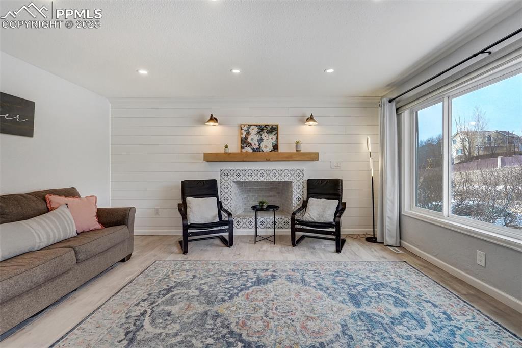Image 2 of 31: Living area with recessed lighting, LVP flooring and shiplap walls around t