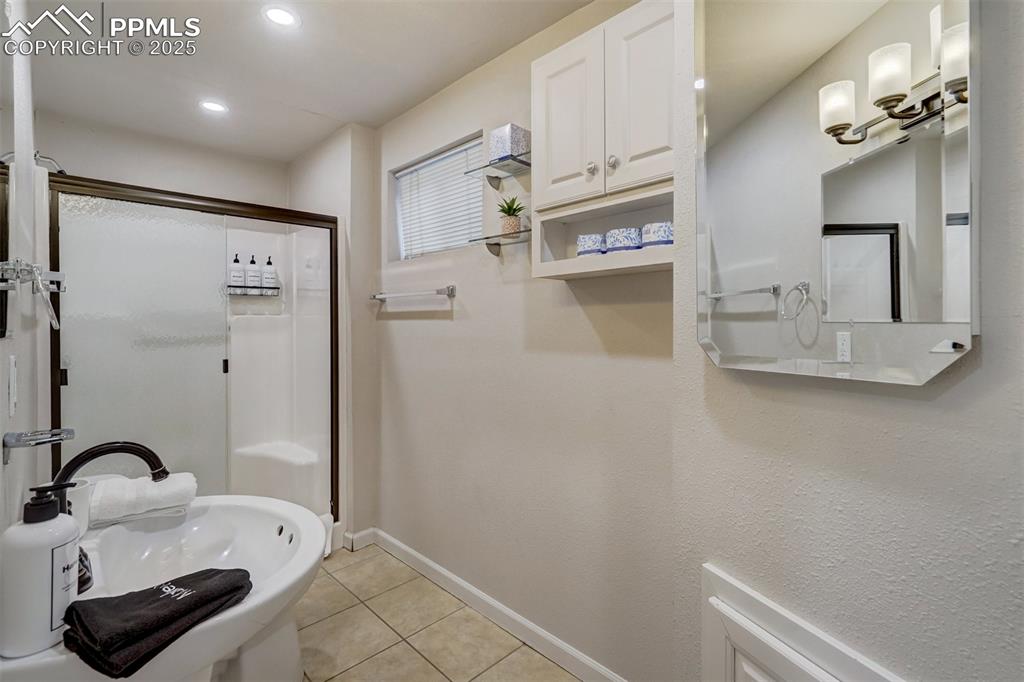 Image 23 of 31: Basement bathroom featuring a shower, light tile patterned flooring, and re