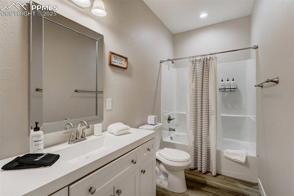 Image 31 of 31: Cottage bathroom featuring shower/bath combo with shower curtain, LVP and v