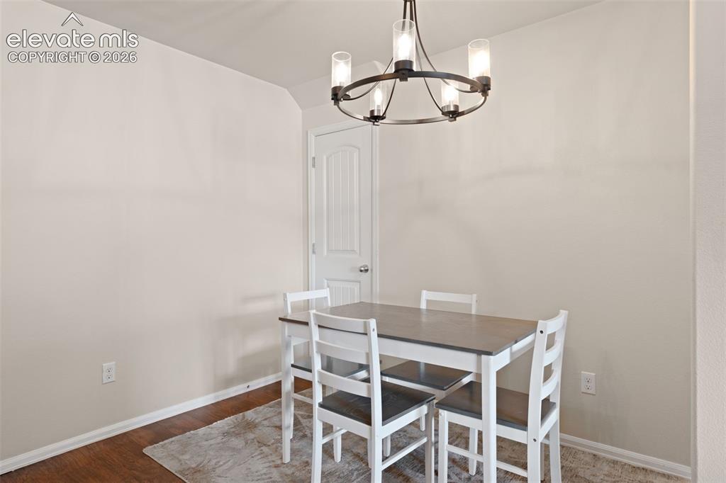 Image 13 of 32: Neutral wall paint, wood-finish flooring, and a six-panel door
