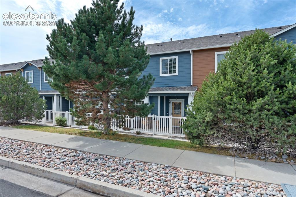 Image 7 of 32: Two-story exterior with multi-toned siding, white trim windows, and a cover