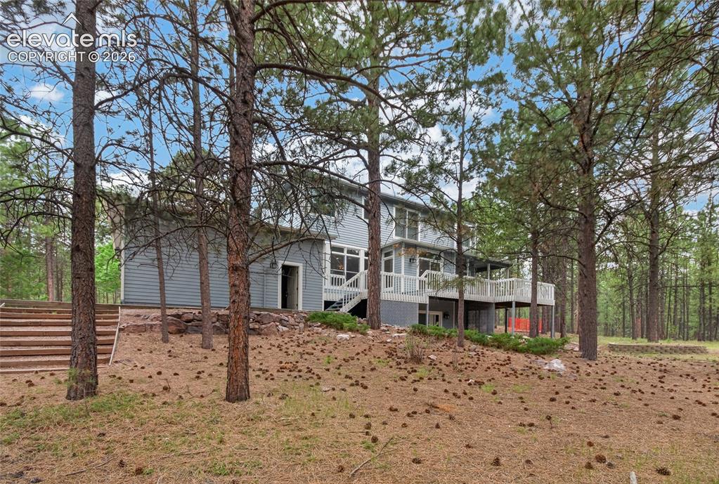 Image 13 of 46: Exterior featuring light grey horizontal siding, a multi-level wood deck wi