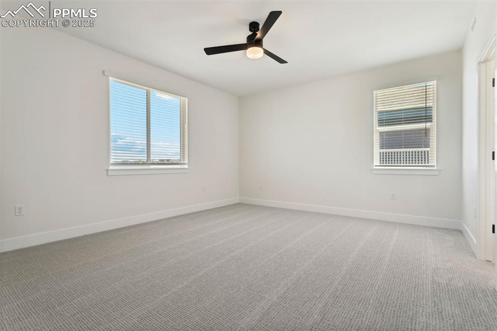 Image 4 of 15: Spare room featuring baseboards, a ceiling fan, and light colored carpet