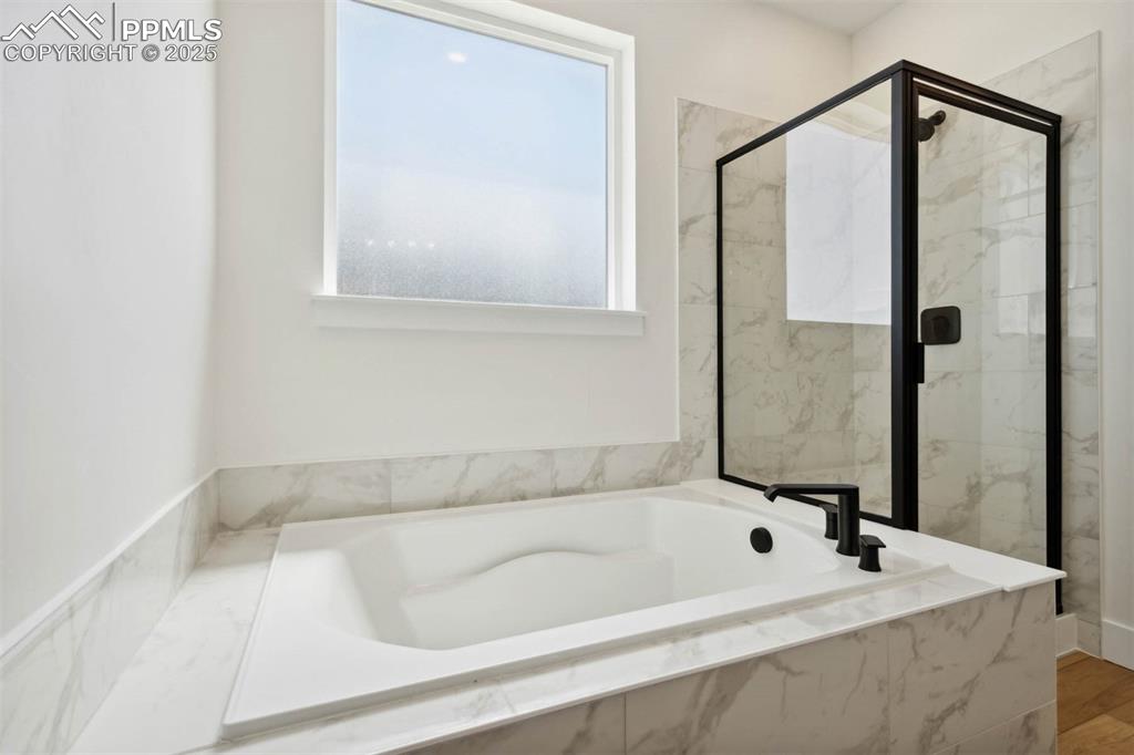 Image 5 of 15: Full bath with a bath and a marble finish shower