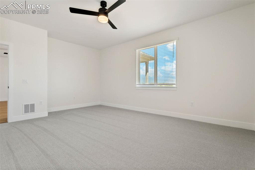 Image 7 of 15: Unfurnished room with baseboards, carpet flooring, ceiling fan, and visible