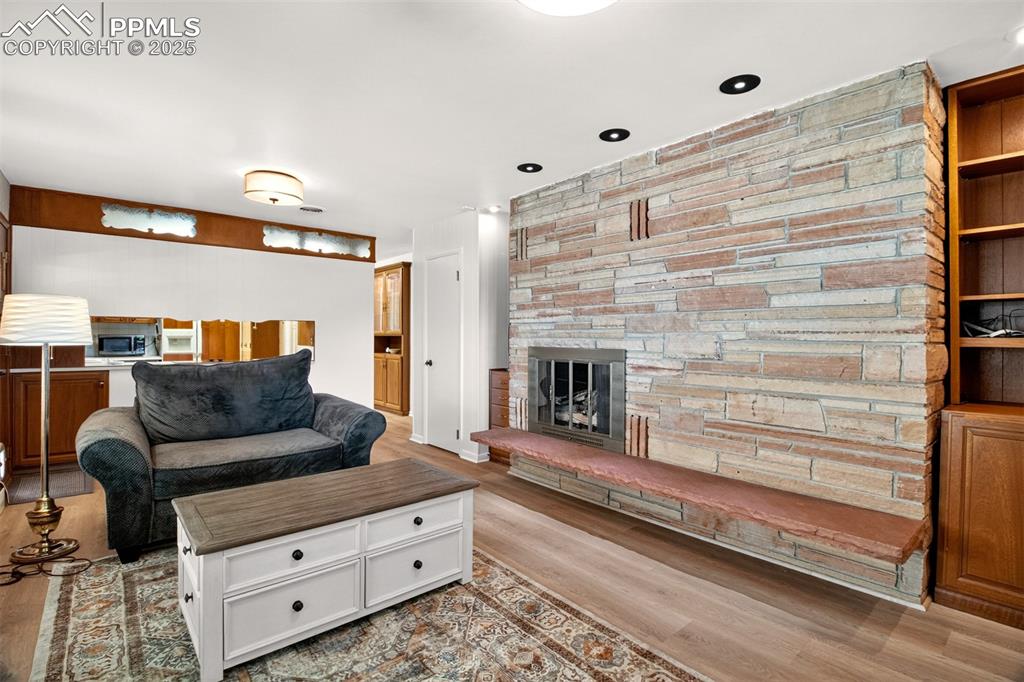 Image 10 of 43: Living area with wood finished floors and a fireplace