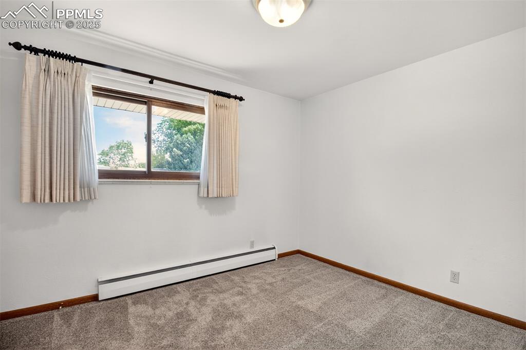 Image 16 of 43: Carpeted empty room with a baseboard radiator and baseboards