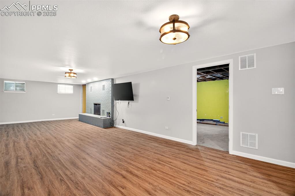 Image 19 of 43: Unfurnished living room with a fireplace and wood finished floors