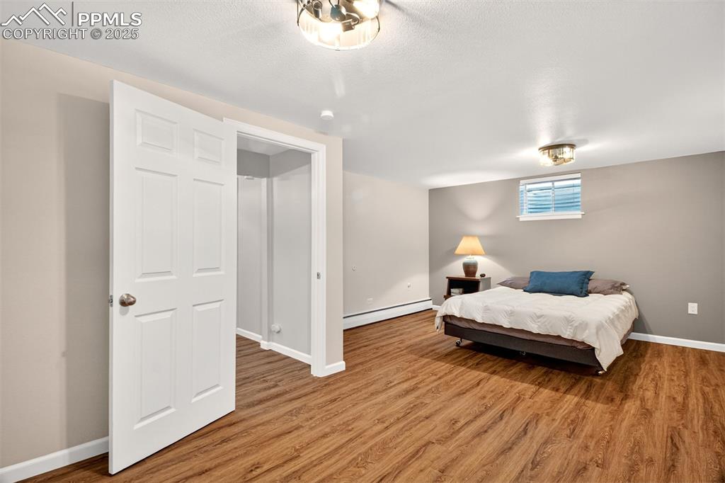 Image 23 of 43: Bedroom with light wood-style flooring and baseboard heating