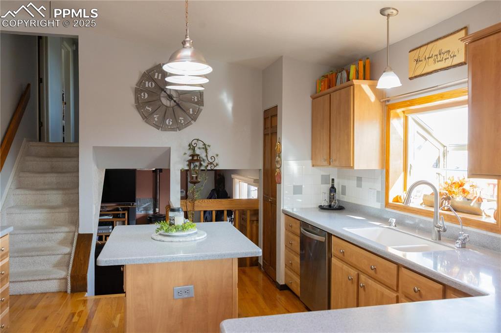 Image 13 of 49: Kitchen featuring light wood-type flooring, a kitchen island, stainless ste