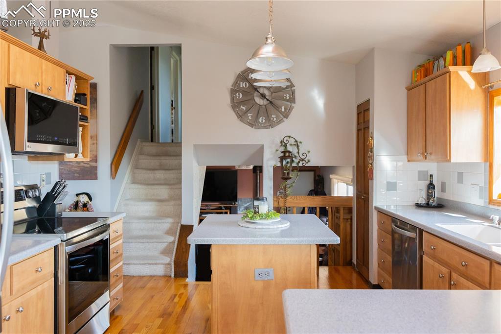 Image 15 of 49: Kitchen with decorative backsplash, appliances with stainless steel finishe