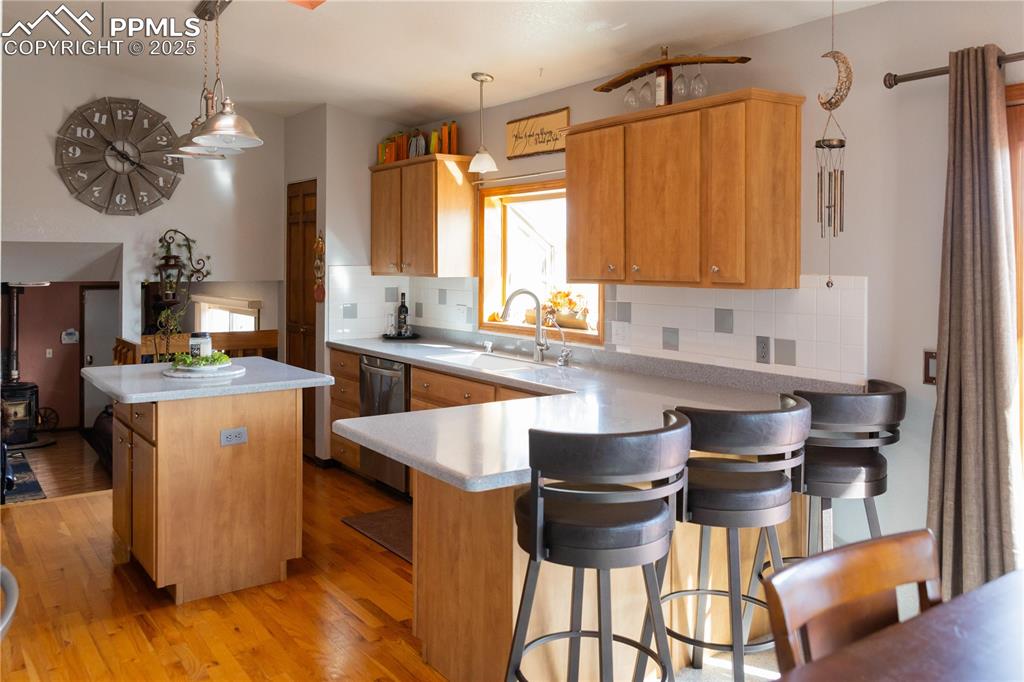 Image 17 of 49: Kitchen with a kitchen bar, light wood-type flooring, a center island, tast