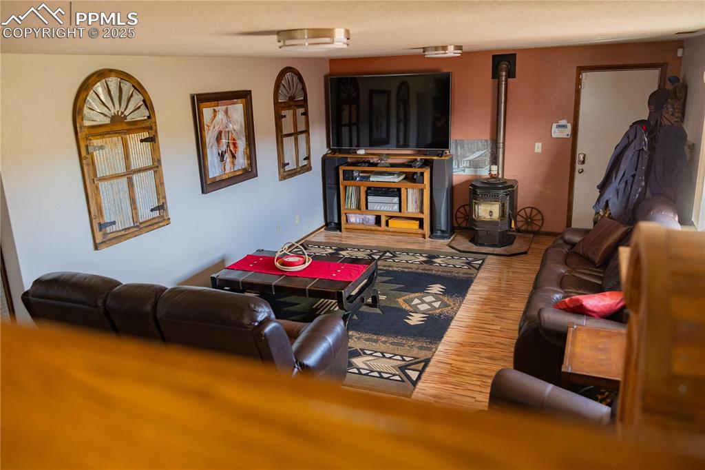 Image 23 of 49: Living area with a wood stove and wood finished floors