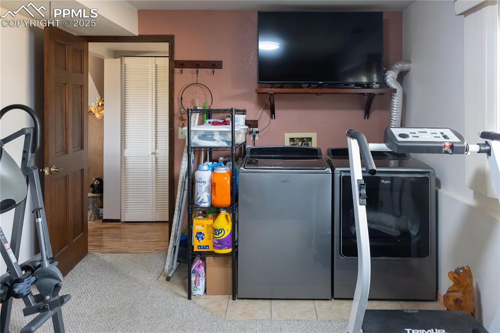 Image 25 of 49: Laundry room with washer and dryer and light tile patterned flooring