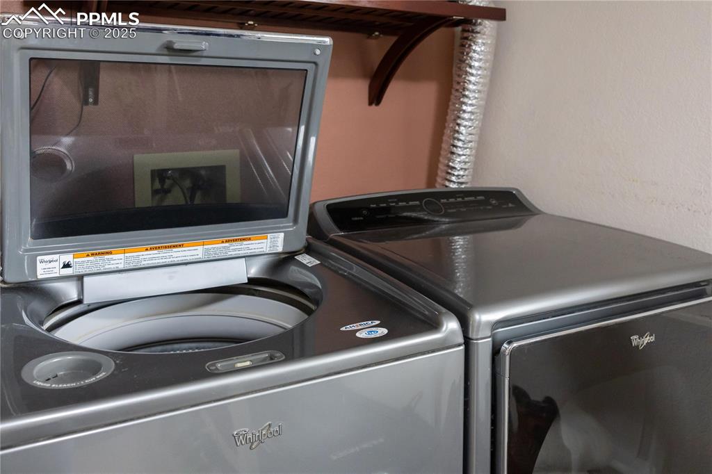 Image 26 of 49: Washroom featuring separate washer and dryer