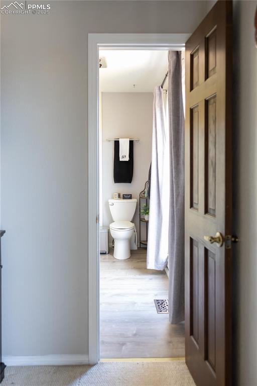 Image 29 of 49: Bathroom featuring a shower with shower curtain and light wood-style floors