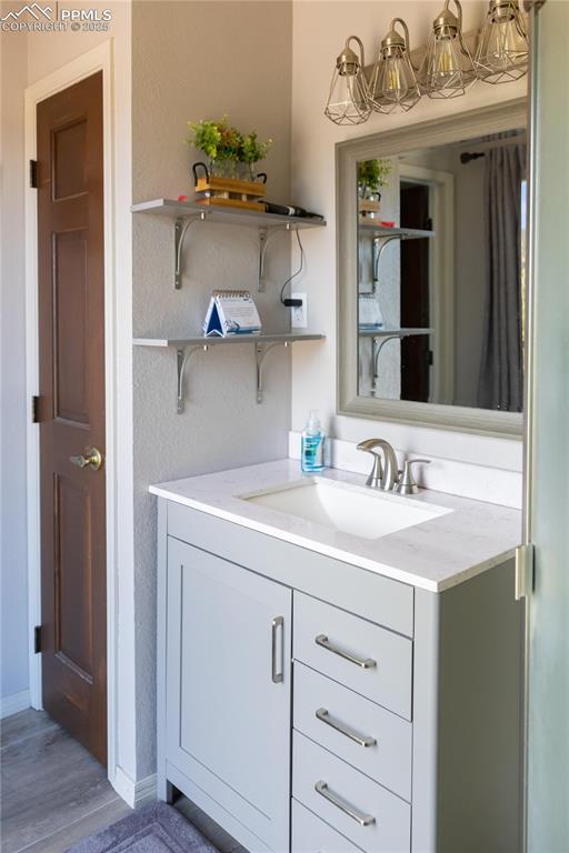 Image 31 of 49: Bathroom featuring vanity, light wood finished floors, and a textured wall