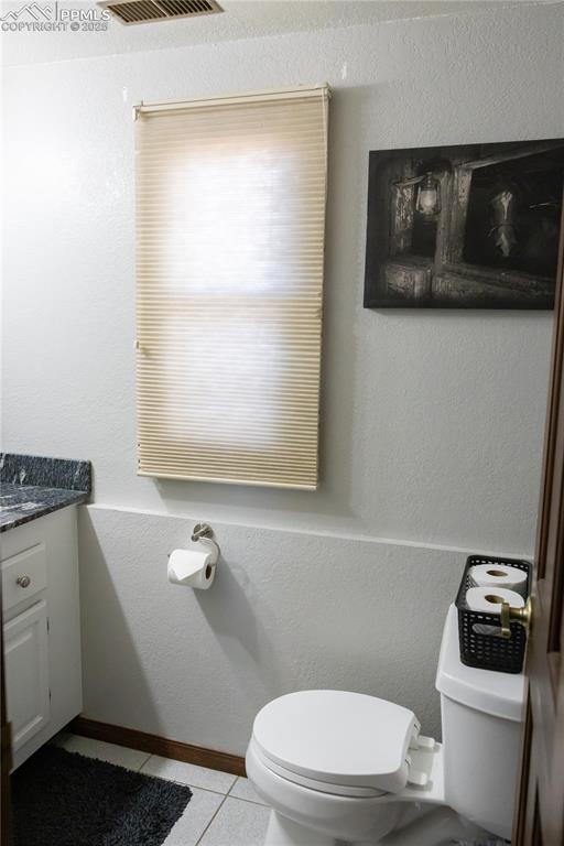 Image 46 of 49: Bathroom with tile patterned flooring, a textured wall, and vanity