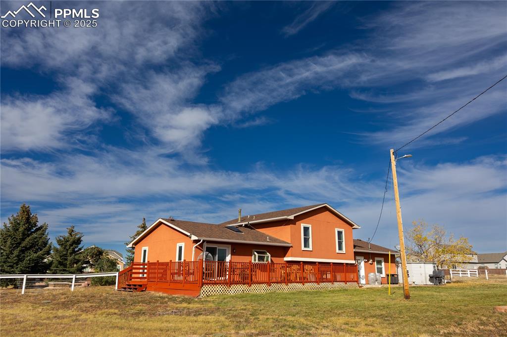 Image 7 of 49: Back of house with a deck and a shingled roof