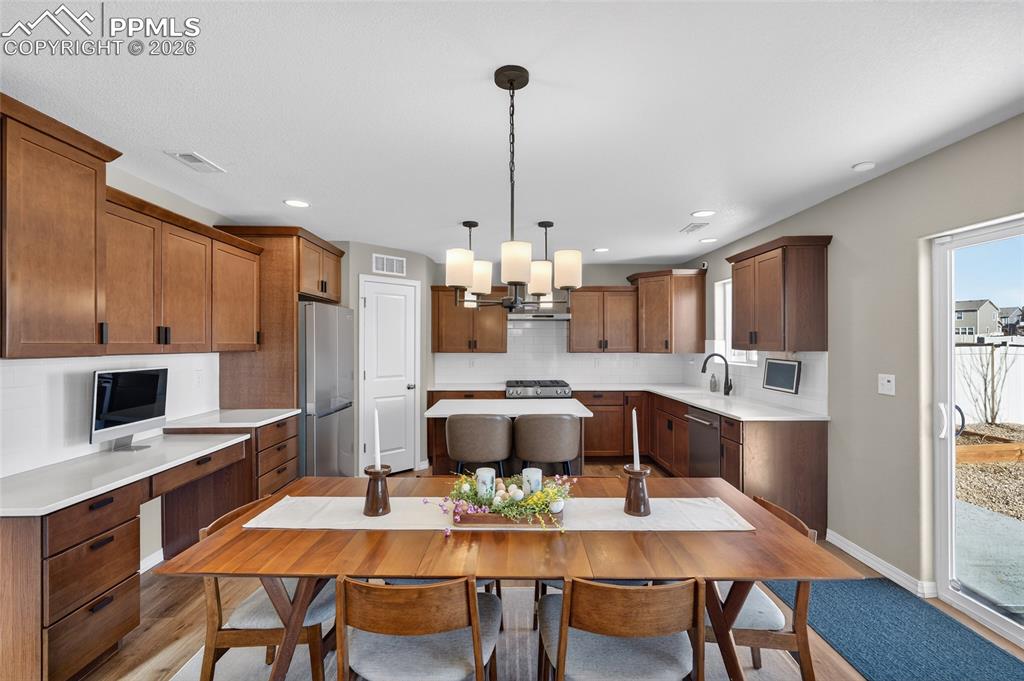 Image 10 of 38: Kitchen with a kitchen island, pendant lighting, stainless steel appliances