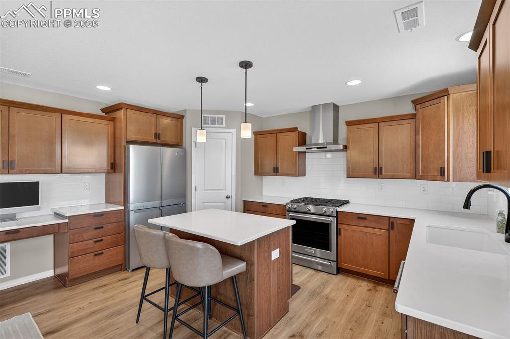 Image 11 of 38: Kitchen featuring stainless steel appliances, wood finish cabinetry, backsp