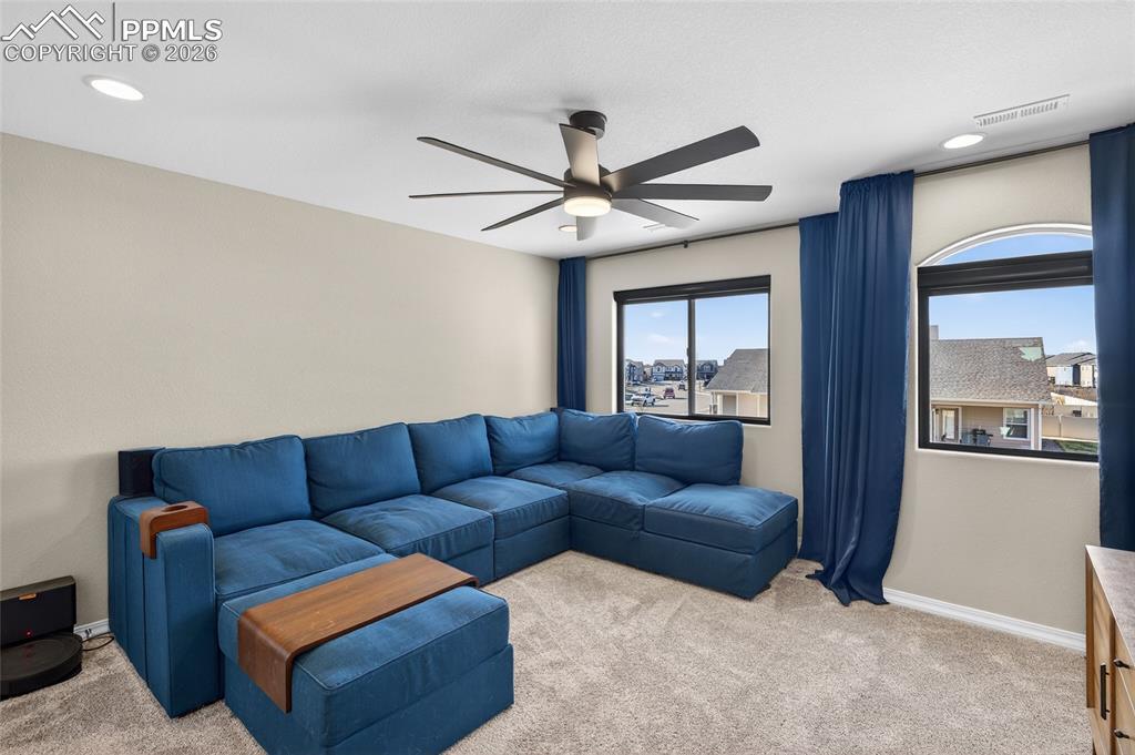 Image 16 of 38: Living room with light carpet, ceiling fan, and recessed lighting