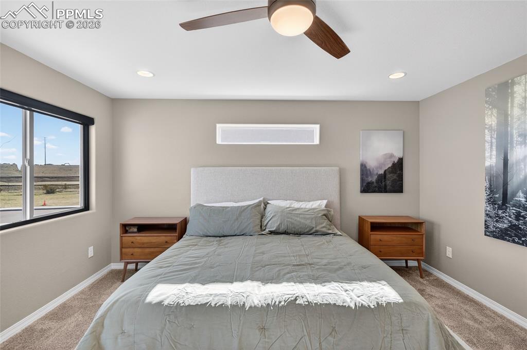 Image 18 of 38: Bedroom with light colored carpet, a ceiling fan, and recessed lighting