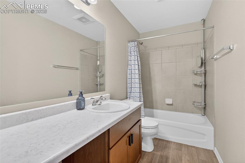 Image 26 of 38: Bathroom with vanity, shower / bath combo, and light wood finished floors