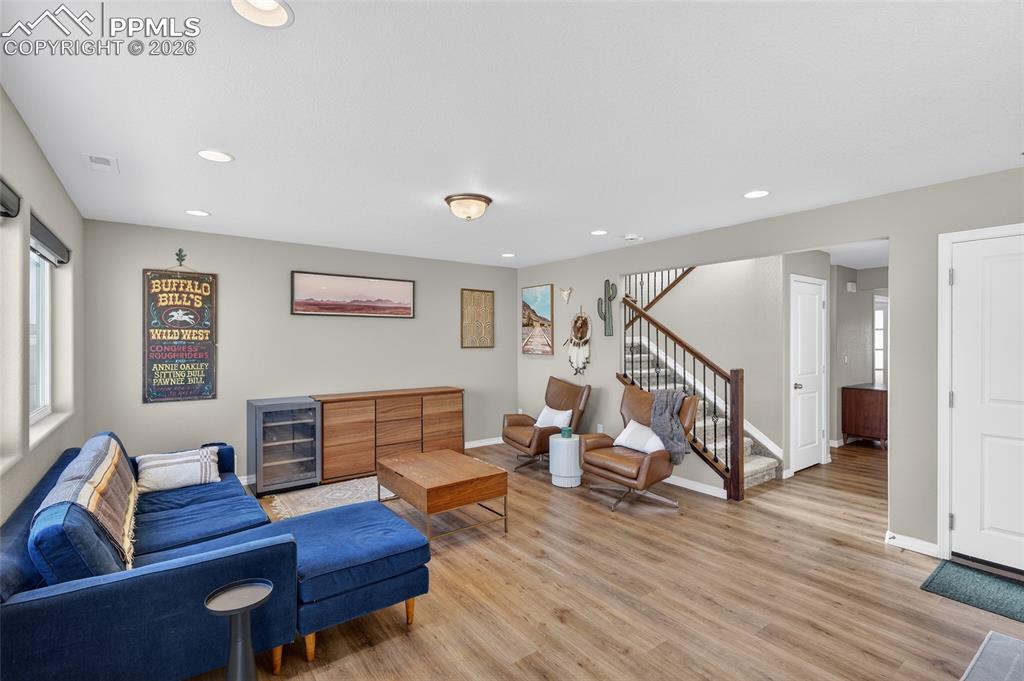 Image 5 of 38: Living room with light wood-type flooring, wine cooler, and recessed lighti