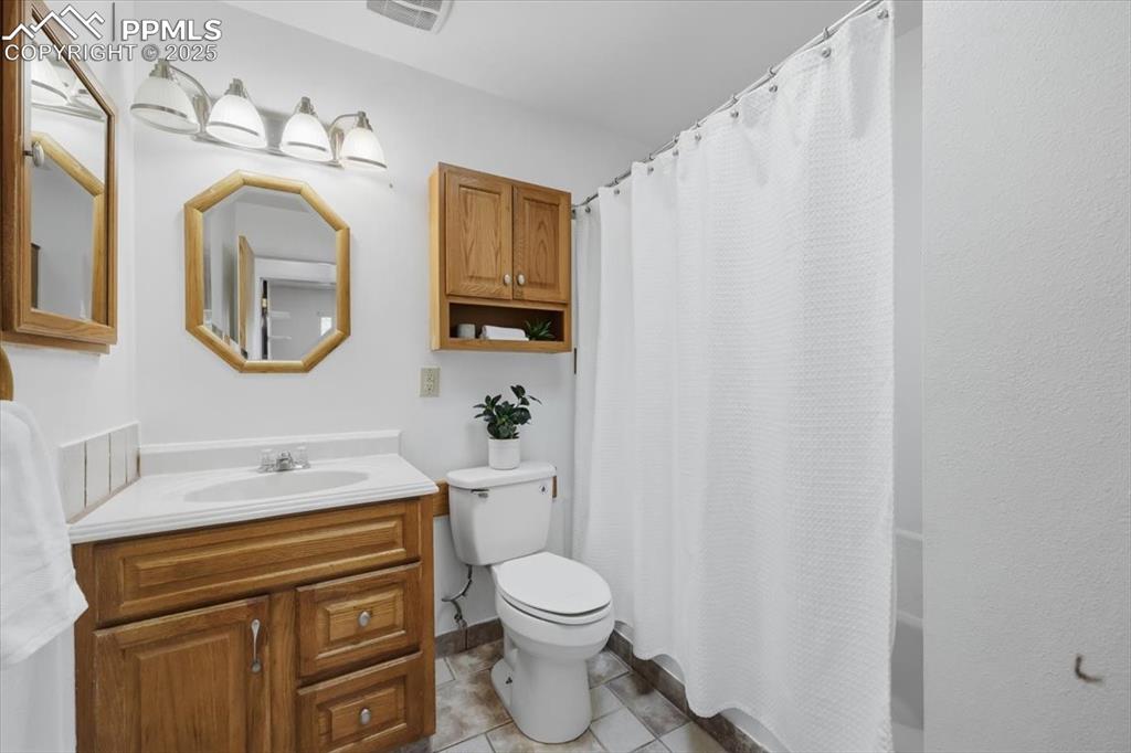 Image 13 of 26: Bathroom with vanity, light tile patterned floors, and shower / tub combo w