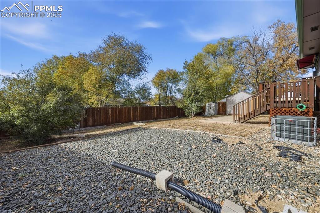 Image 20 of 26: Fenced backyard featuring stairs and a shed