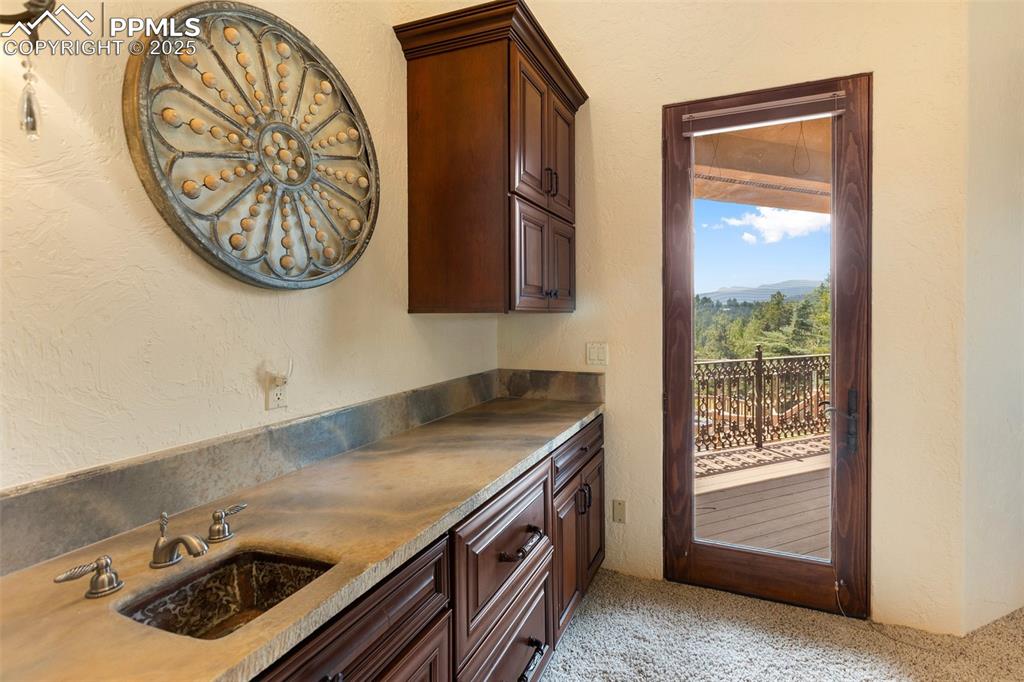 Image 36 of 50: Personal bar with private walk out patio.