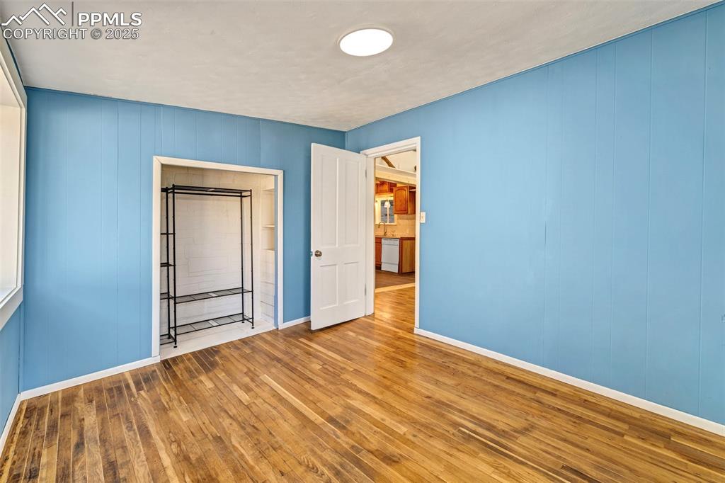 Image 12 of 34: Blue Bedroom with updated fixtures, fresh paint, and natural hardwood floor