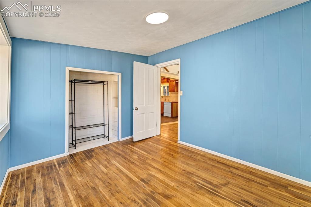 Image 12 of 34: Blue Bedroom with updated fixtures, fresh paint, and natural hardwood floor
