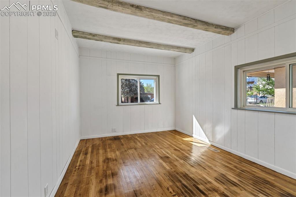 Image 8 of 34: White Bedroom with hardwood floors