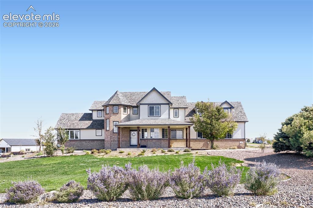 Image 1 of 37: A striking two-story residence with a brick-clad turret, multi-gable roofli