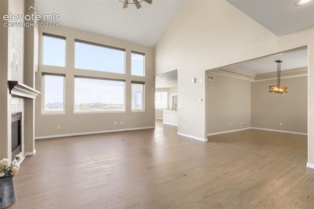 Image 10 of 37: Sunlit, vaulted family room featuring a wall of floor-to-ceiling windows, o