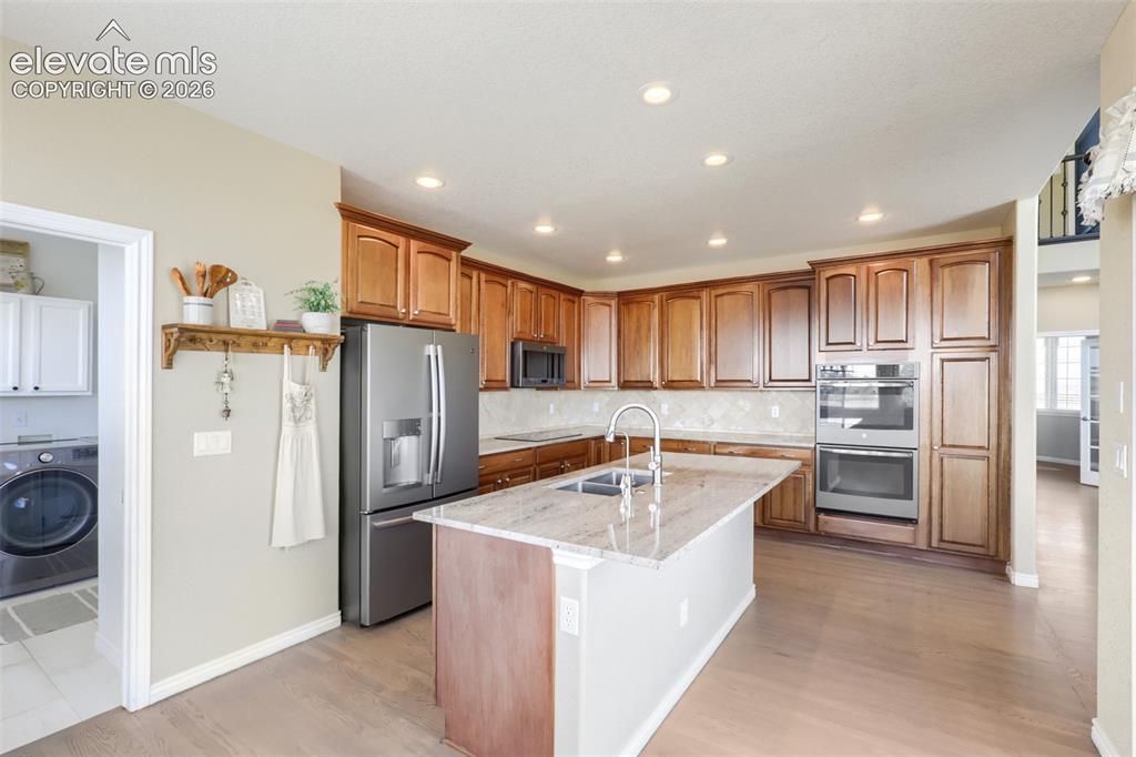 Image 11 of 37: Step into a beautifully appointed kitchen featuring warm maple cabinetry, g