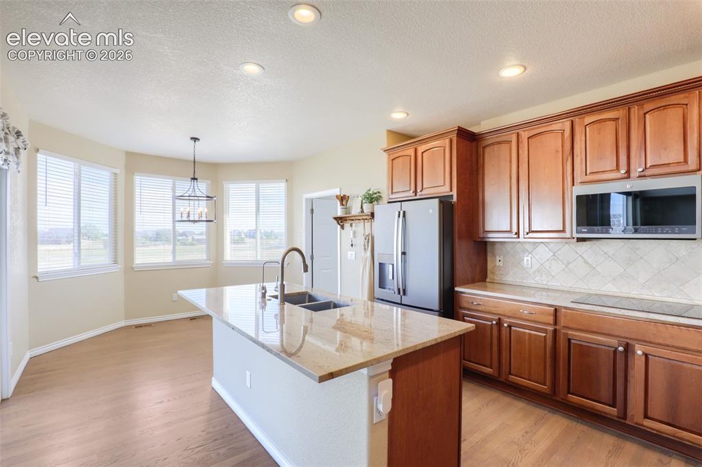 Image 12 of 37: Well-appointed kitchen showcasing a sleek induction glass cooktop, granite