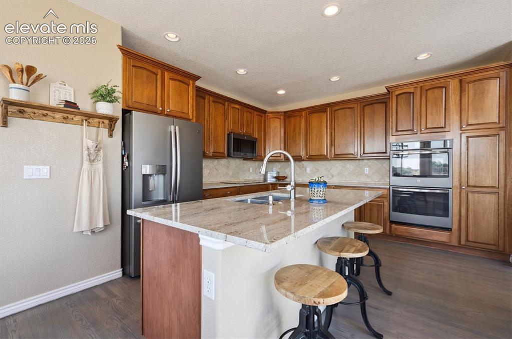 Image 13 of 46: Kitchen featuring wood-finish flooring, recessed lighting, and a kitchen is