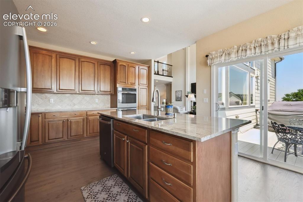 Image 14 of 46: Kitchen featuring wood-finish cabinetry, stainless steel appliances, granit